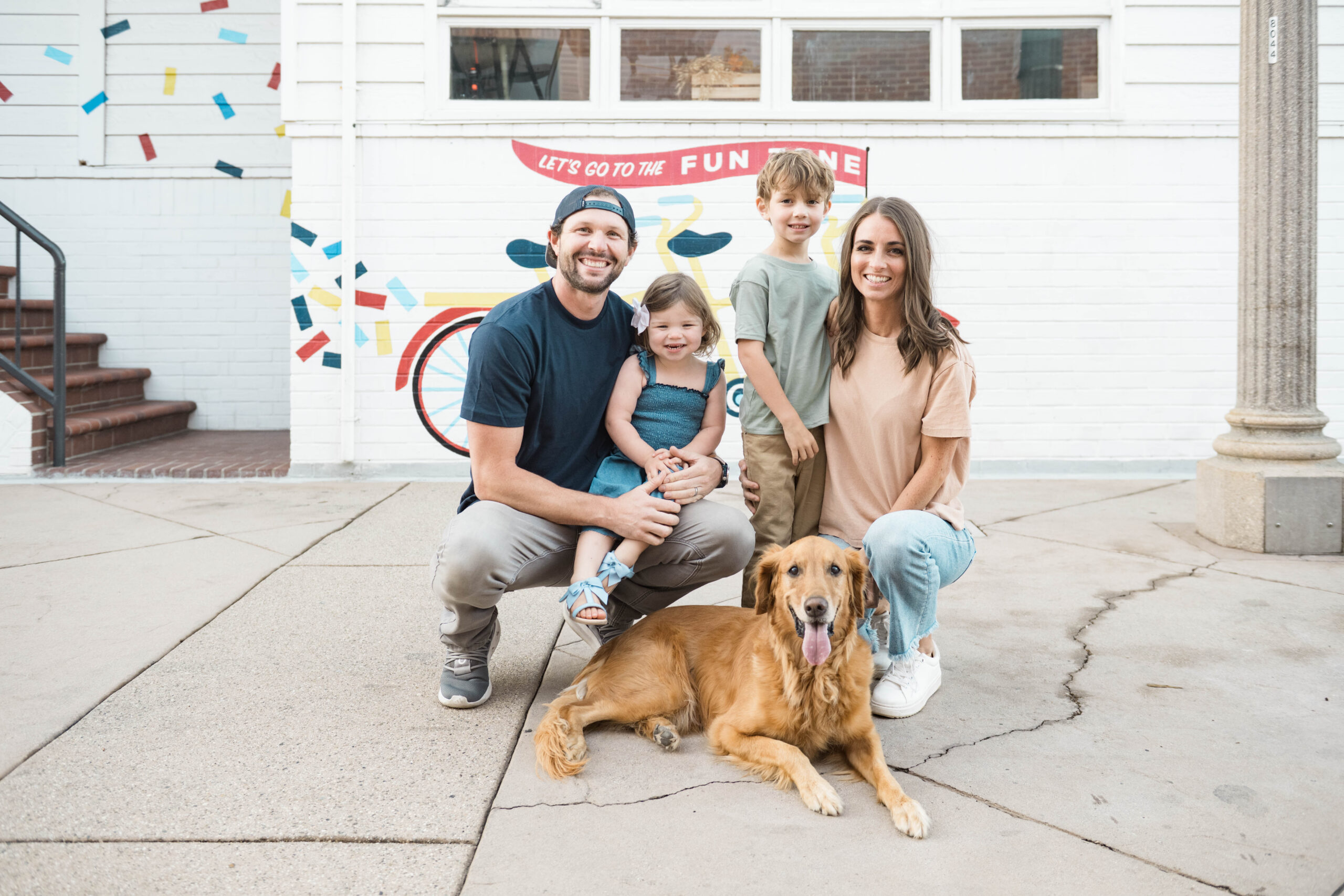 Family portrait with golden retriever in front of a colorful mural, Southern California family session