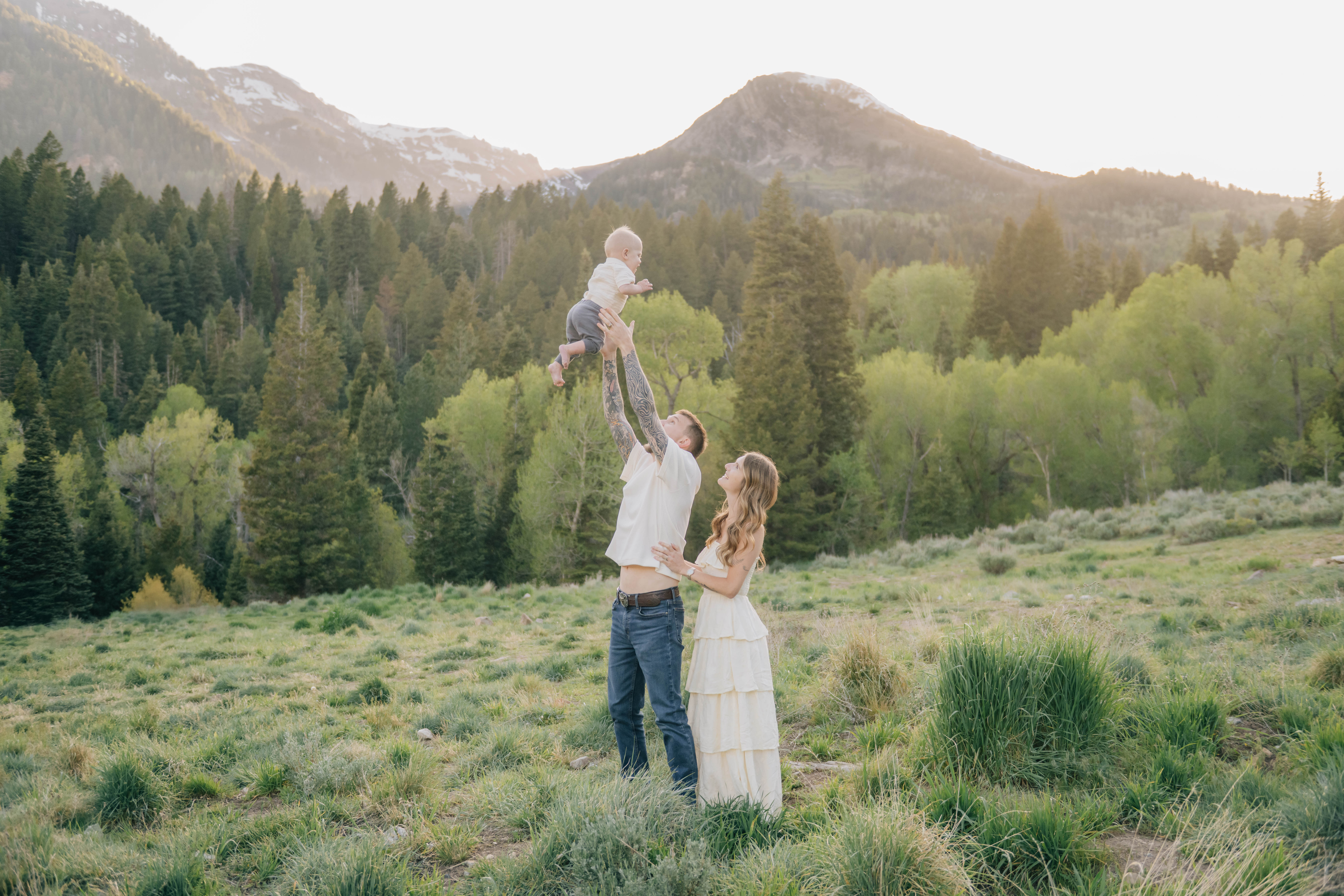 Dad throwing baby in air in a family summer session in the mountains