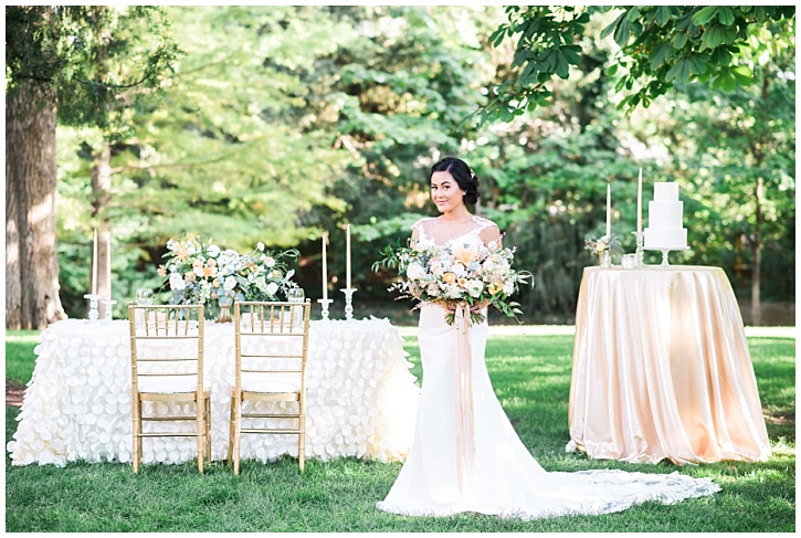Bride stands next to table set with flowers and gold wedding decor | Brooke Bakken | Utah Wedding Photographer