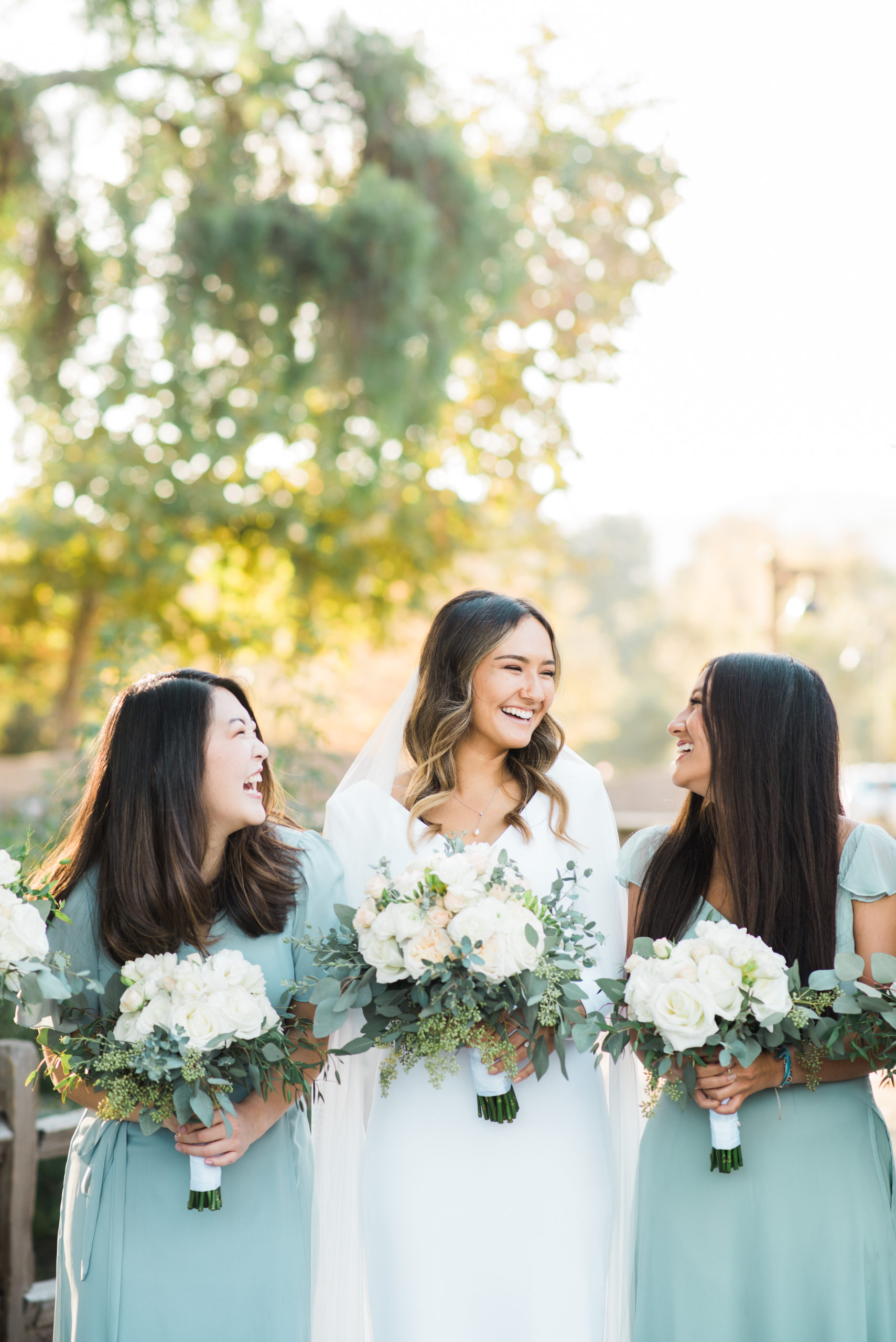 Bride and Bridesmaids Laughing in a Garden Wedding in Orange County