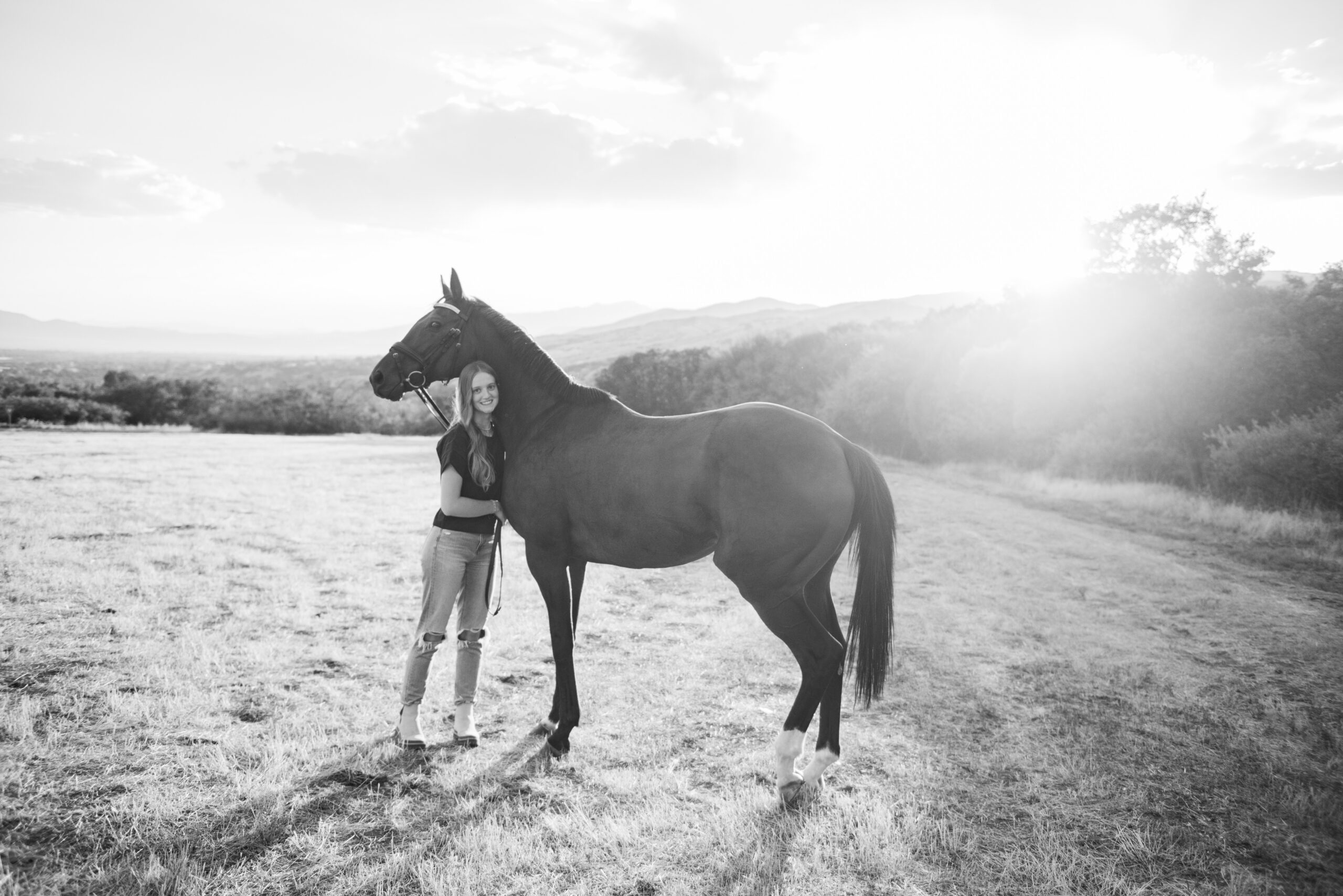 black and white senior portrait of a girl and her horse at alpine rodeo grounds