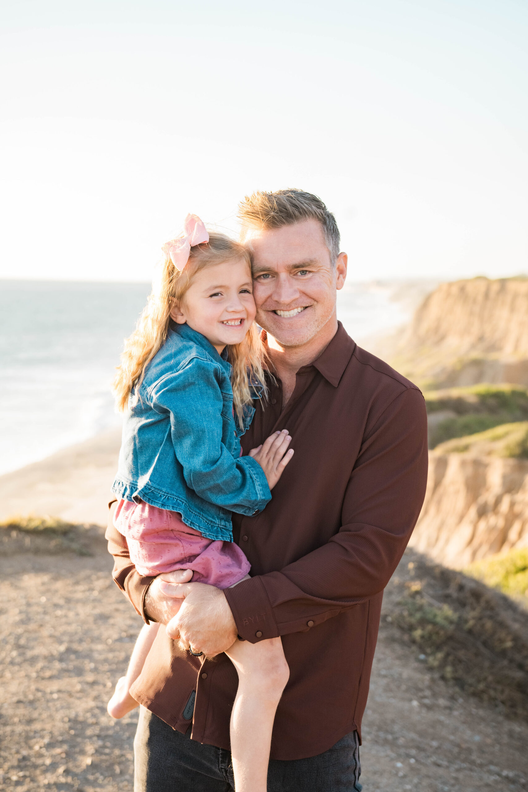 Father holding daughter on the beach during golden hour, Southern California family photography
