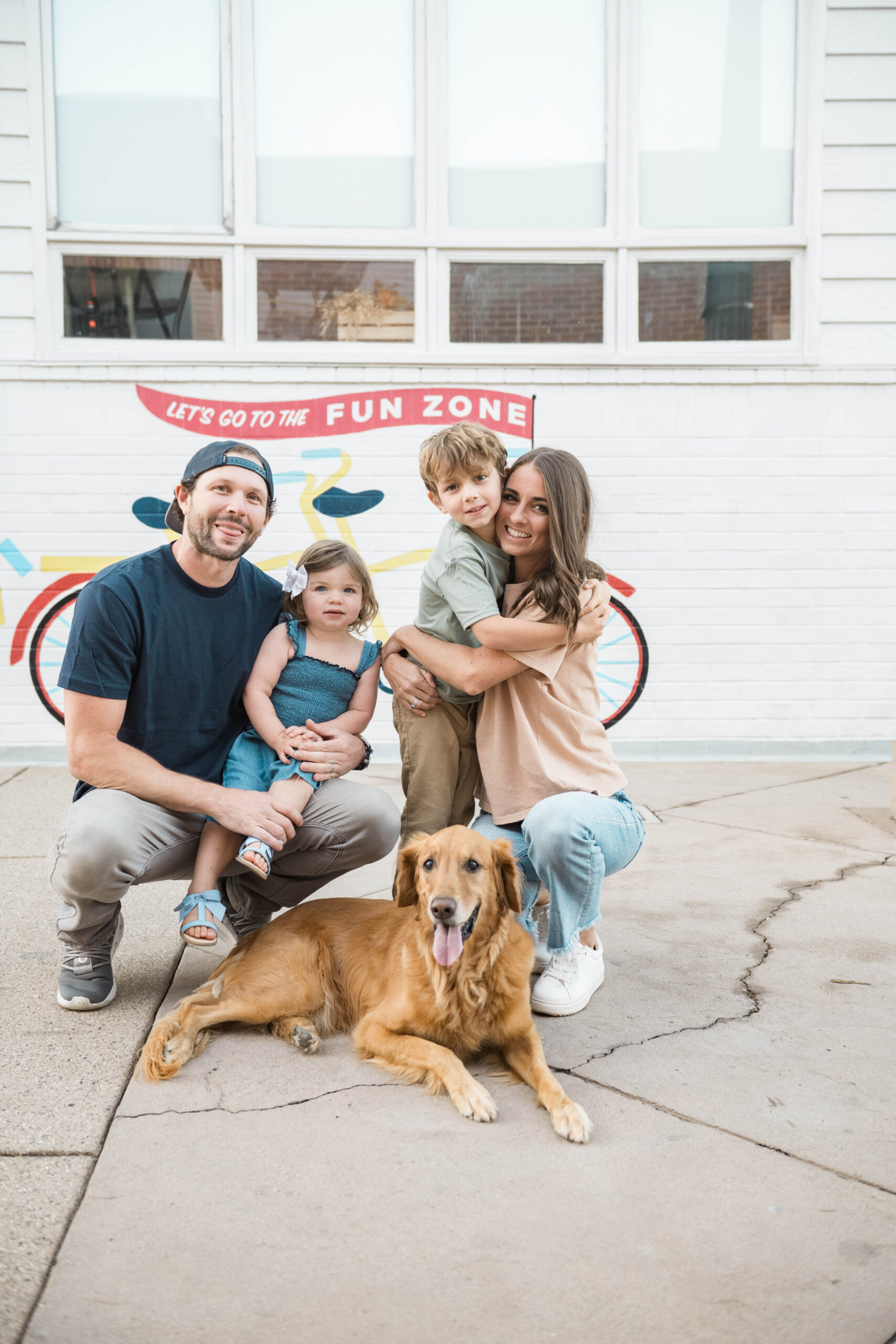 Family portrait with golden retriever in front of a colorful mural, Balboa Fun Zone in a Southern California family session