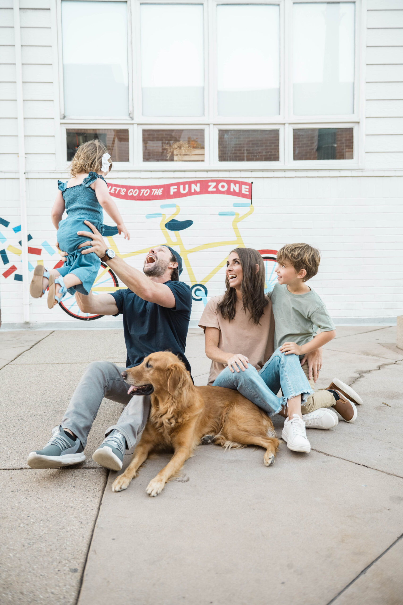 Family portrait with golden retriever in front of a colorful mural, Balboa Fun Zone in a Southern California family session